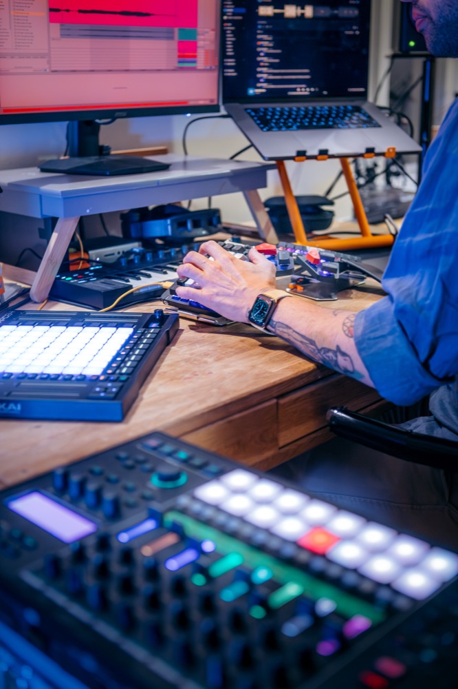 Hands on a controller in front of the studio monitors