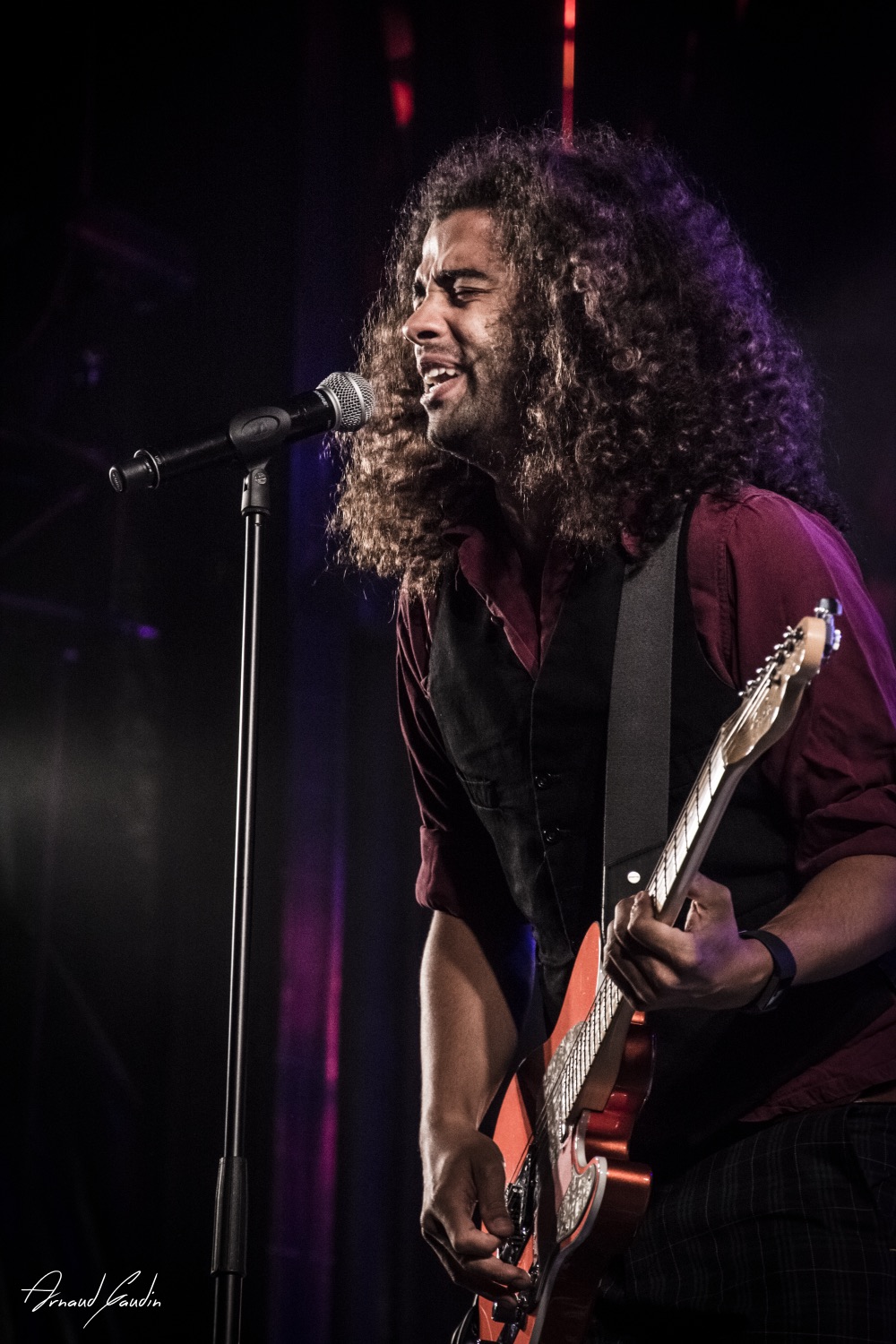Lorne singing and playing guitar on stage